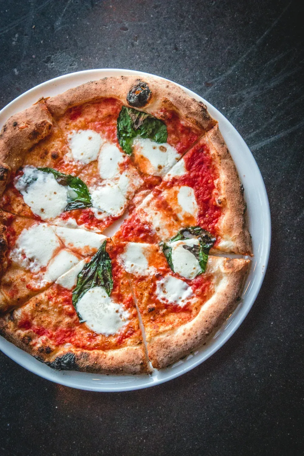 Freshly baked pizza with basil and tomato